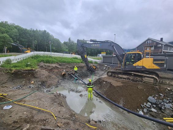 Gravemaskin på steinhaug