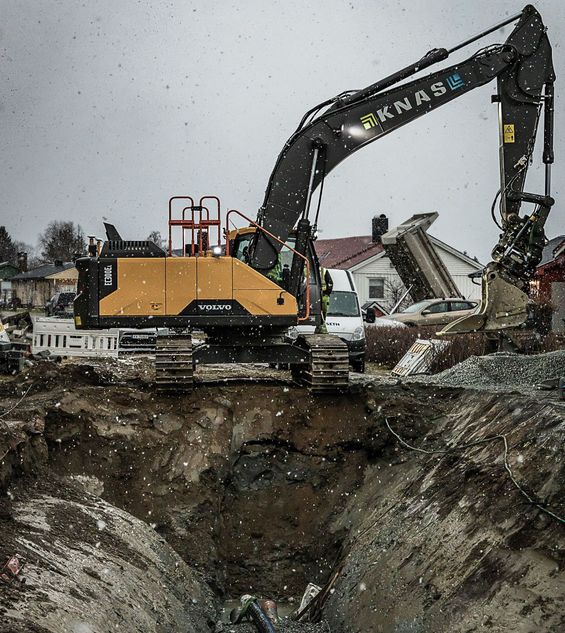 Gravemaskin på steinhaug