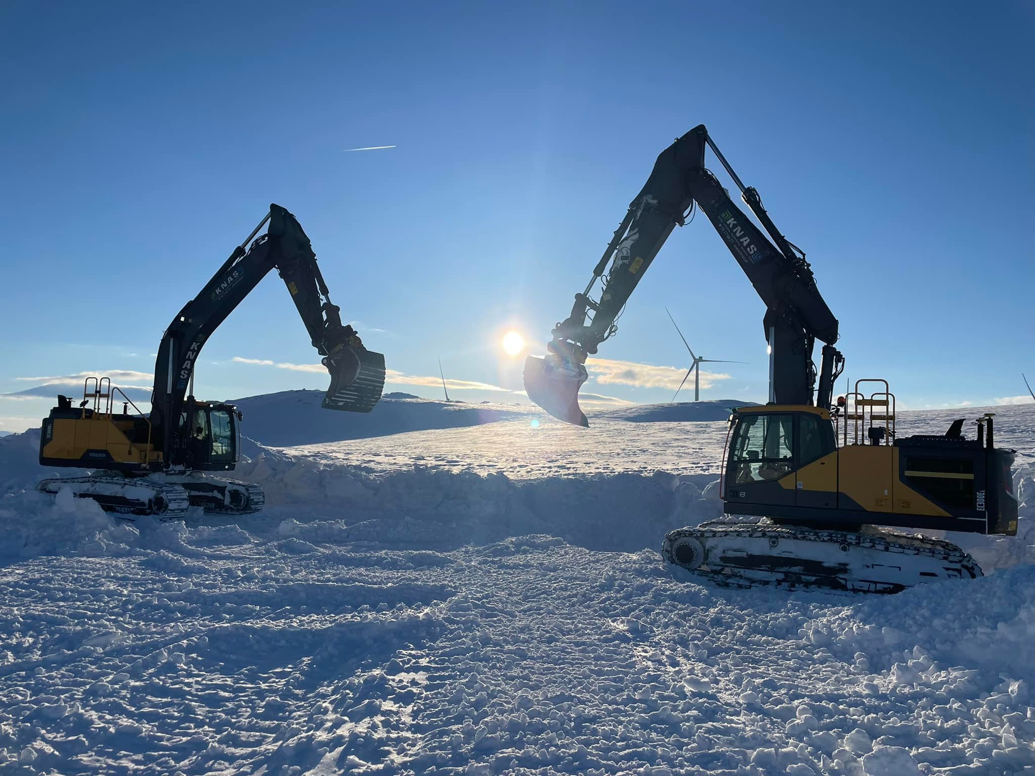Gravemaskin på steinhaug